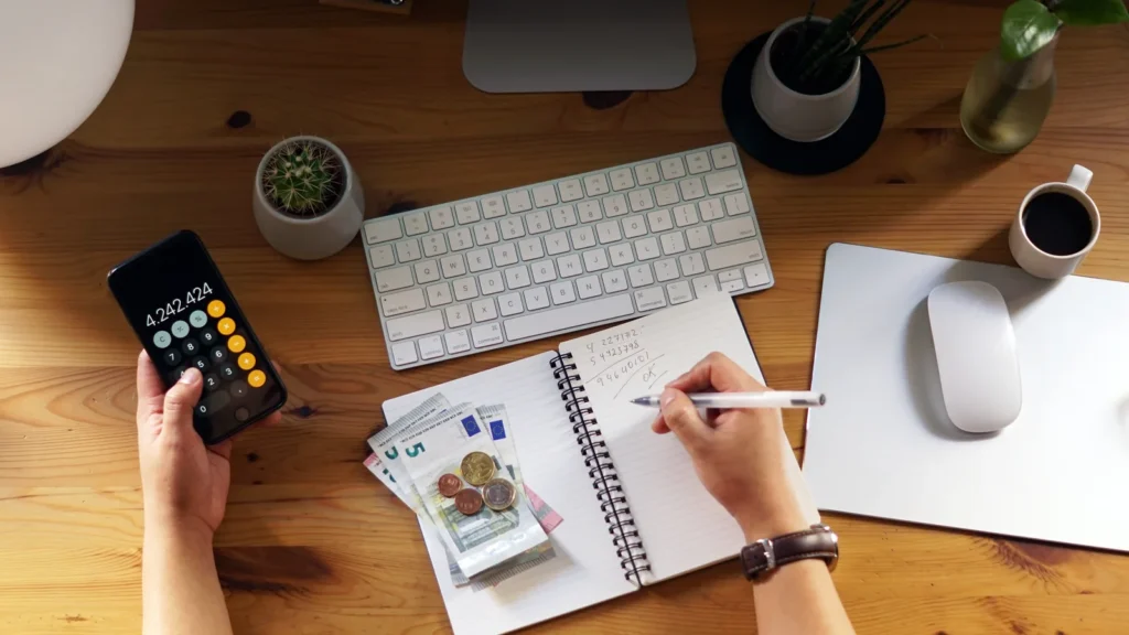 Calculator and notepad used to work out the cost of outsourced B2B appointment setting
